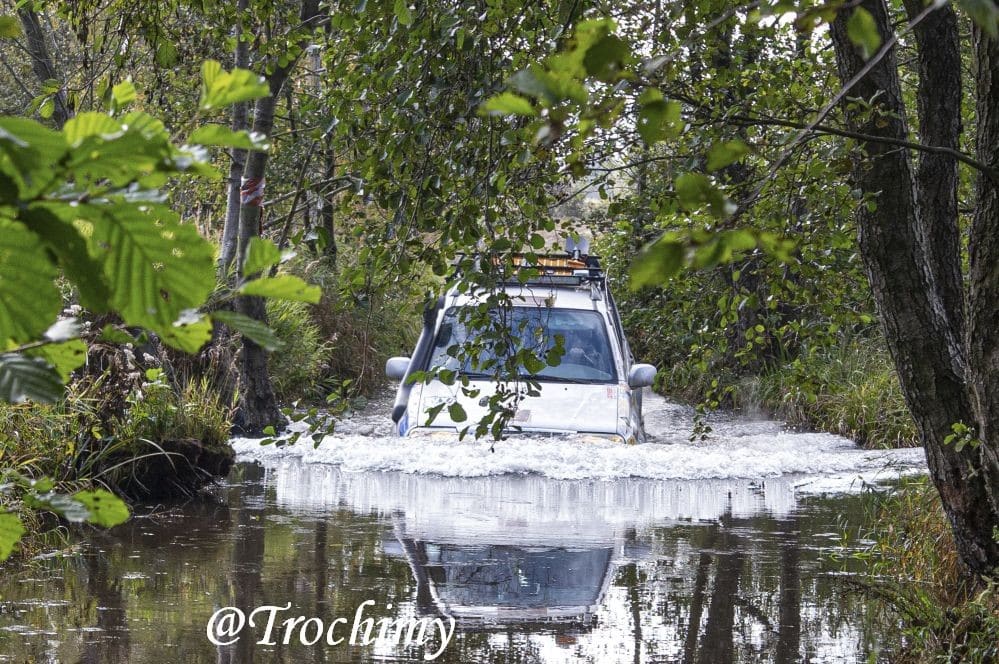 Auto przejeżdża przez wodę w lesie, rozbryzg