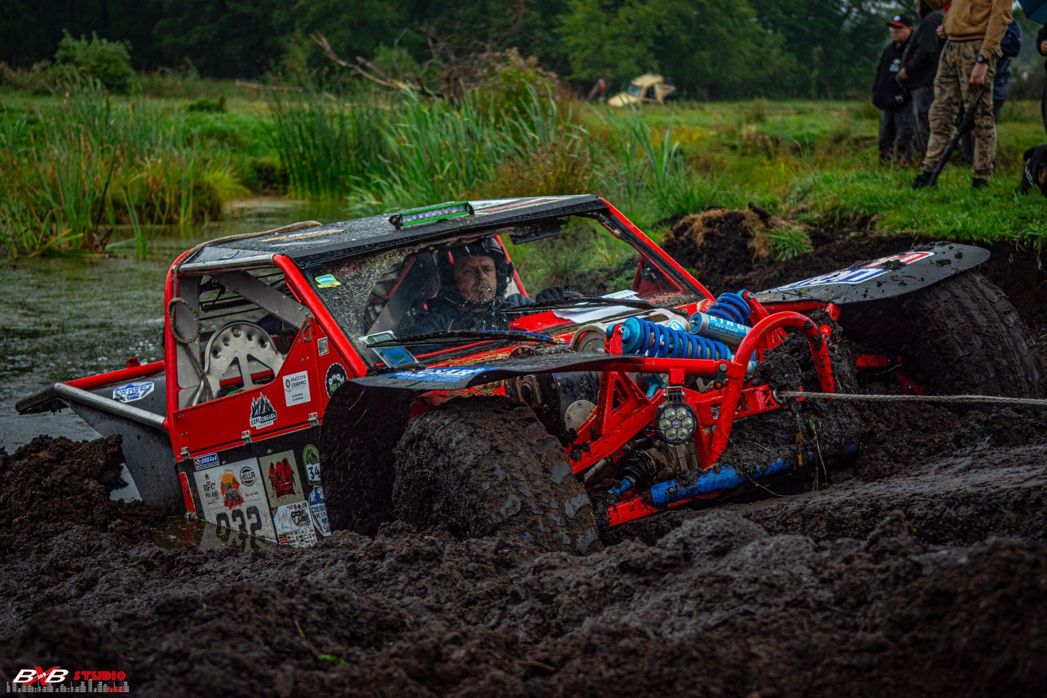 Czerwony buggy w głębokim błocie, lina wyciągarki