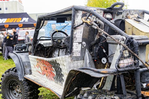 Buggy z grafiką smoka, klatką i pasami transportowymi w strefie serwisowej