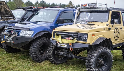 Niebieska terenówka i beżowe Suzuki Samurai z pasem przy wyciągarce