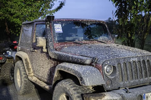Zabłocony szary Jeep Wrangler z wysokim wlotem powietrza w bazie po przejeździe