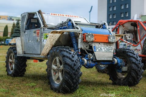 Srebrno-niebieski prototyp terenowy z niebieskimi amortyzatorami na trawie w bazie