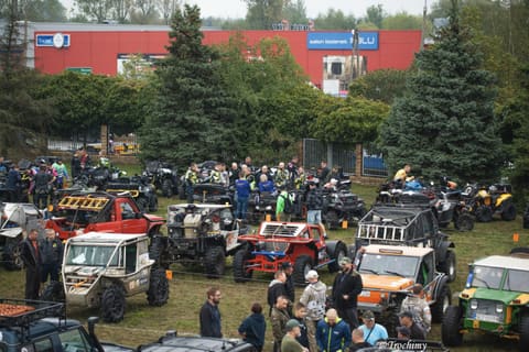 Tłum uczestników, quady i auta terenowe zebrane w parku maszyn przed startem