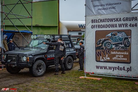Czarny Nissan Patrol w bazie obok banera Bełchatowskiej Grupy Offroadowej WYR 4x4